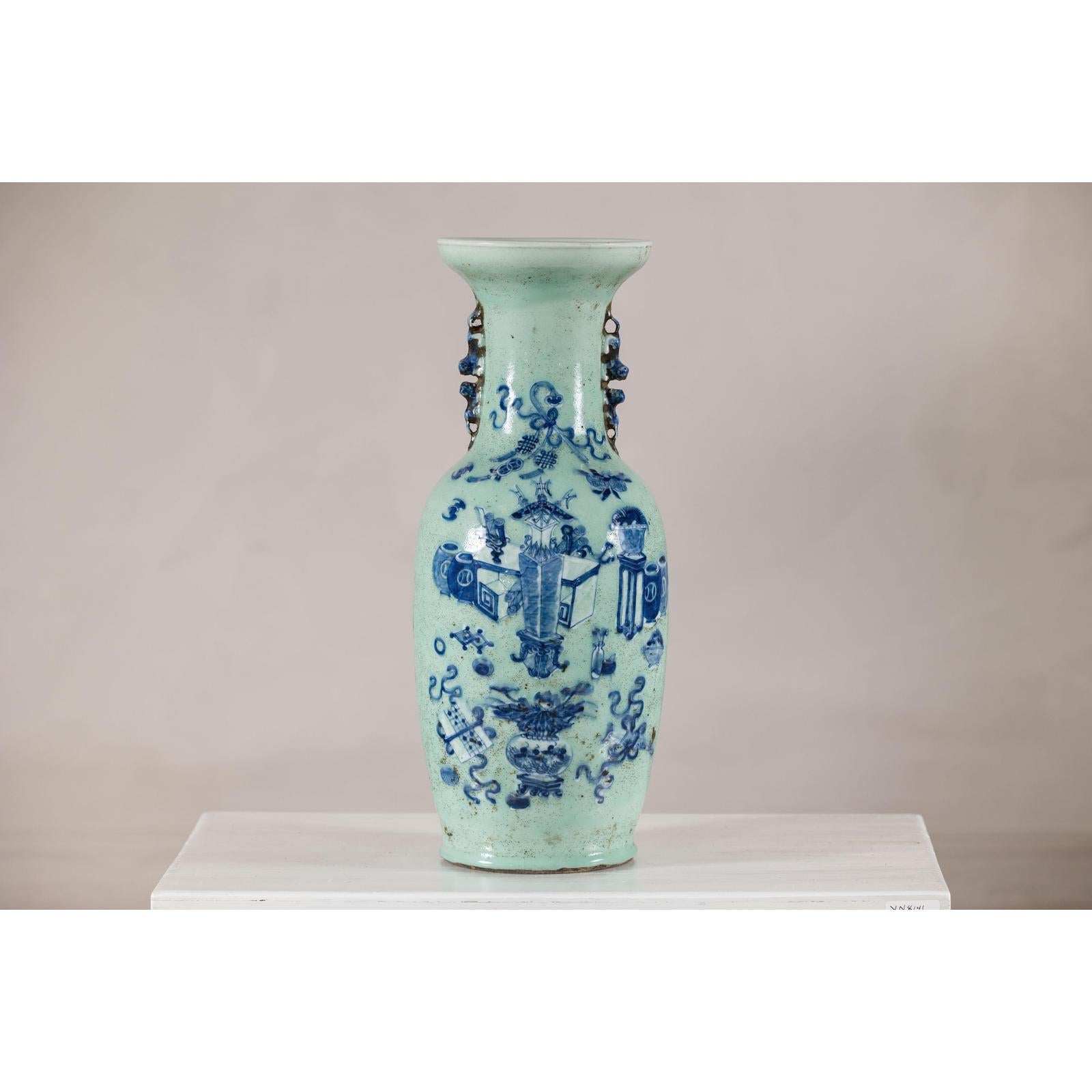 Cobalt blue and white porcelain vase with scholar images and ornate handles, displayed on a white surface.