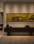Black metal landscape wall panel with mountain and river scene above dark console and vases in modern hallway.
