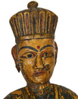 Close-up of a hand-carved, painted antique Indonesian temple statue with a crowned figure on a white background.