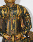Wooden figurine of a seated figure with intricate carvings on a white background