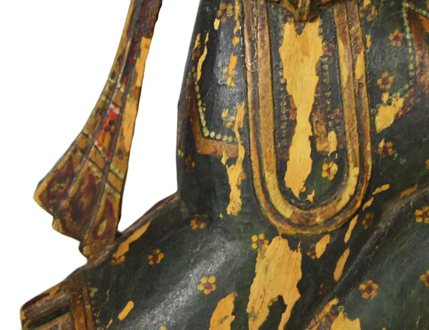 Wooden figurine of a seated figure with intricate carvings on a white background
