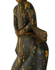 Wooden figurine of a seated figure with intricate carvings on a white background