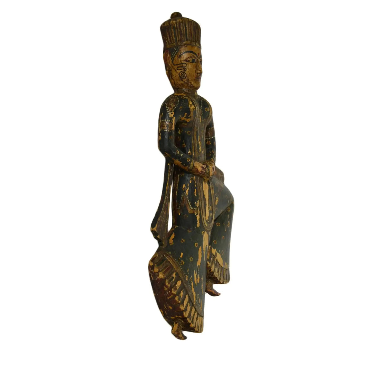 Wooden figurine of a seated figure with intricate carvings on a white background