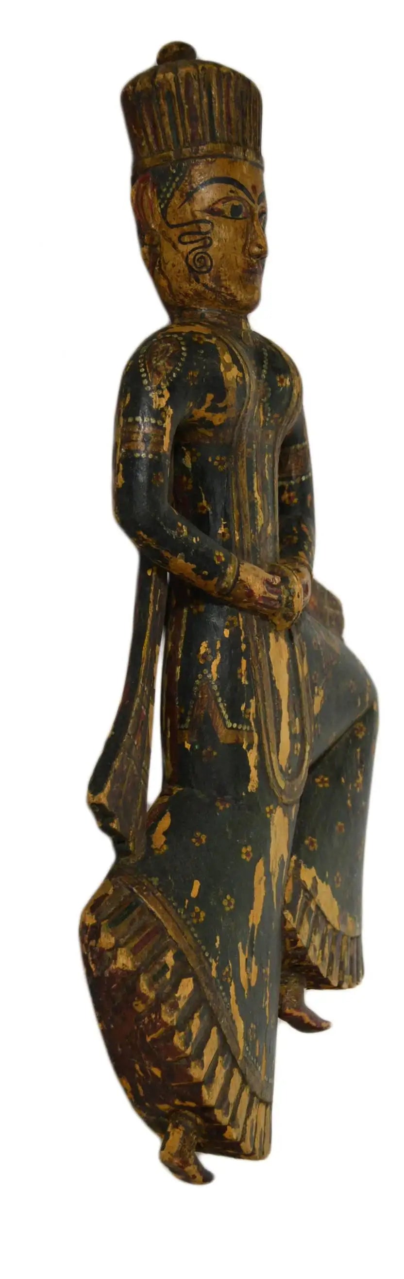 Wooden figurine of a seated figure with intricate carvings on a white background