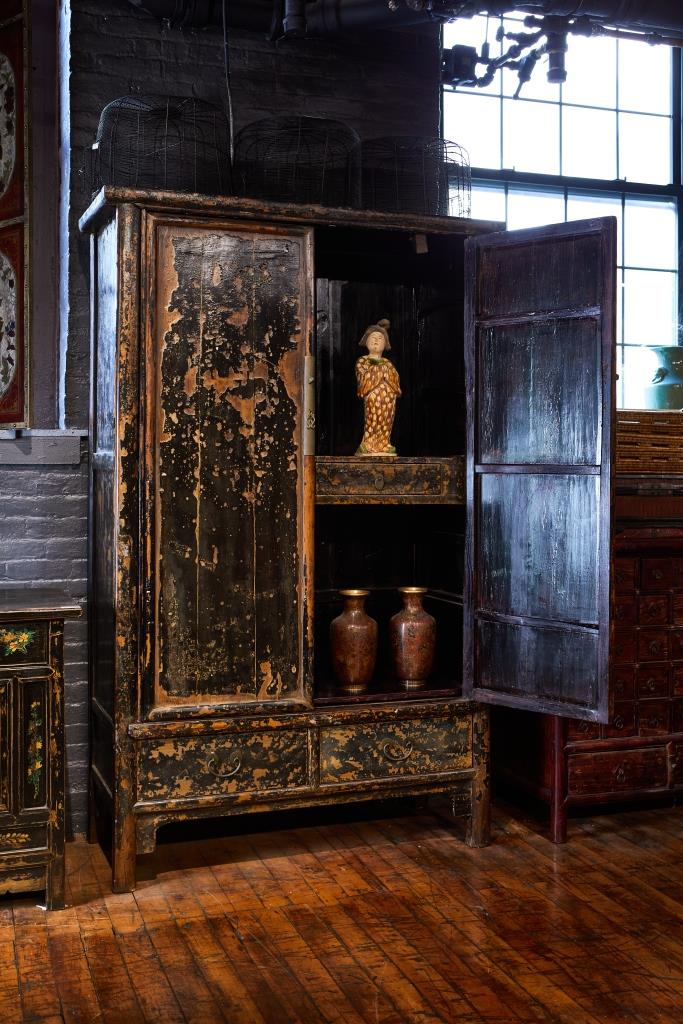 Antique wooden cabinet with open doors displaying decorative items for tv film rental set