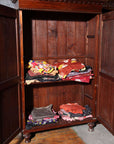 Brown wooden Javanese armoire with two carved doors, 20th century, from Indonesia, against white background.