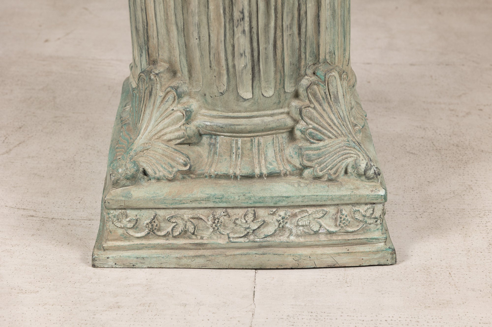 Close-up of verdigris bronze pedestal base and palmette details