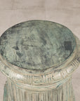 Close-up of round bronze pedestal top with verdigris patina