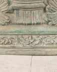 Close-up of bronze pedestal base with scrolling foliate border