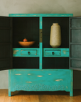 Blue green lacquered wood Qing Dynasty cabinet with carved apron, open doors, brass lock, fruit bowl and vase inside.
