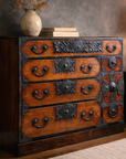 Brown keyaki wood tansu chest with dark metal accents, vase and books on top, Japanese Meiji Period Sendai style.