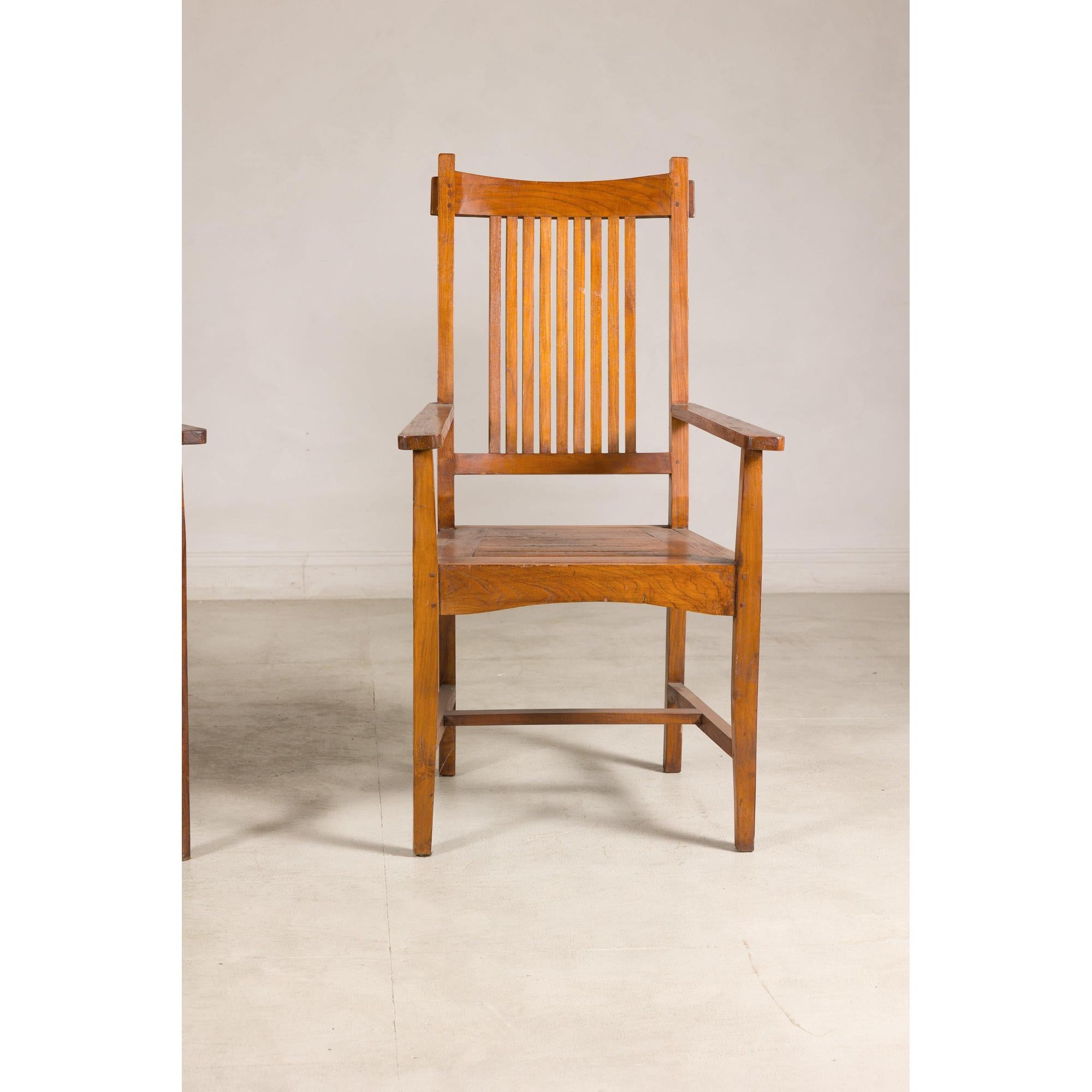 Teak Dutch Colonial armchairs with vertical slats on a light-colored floor.