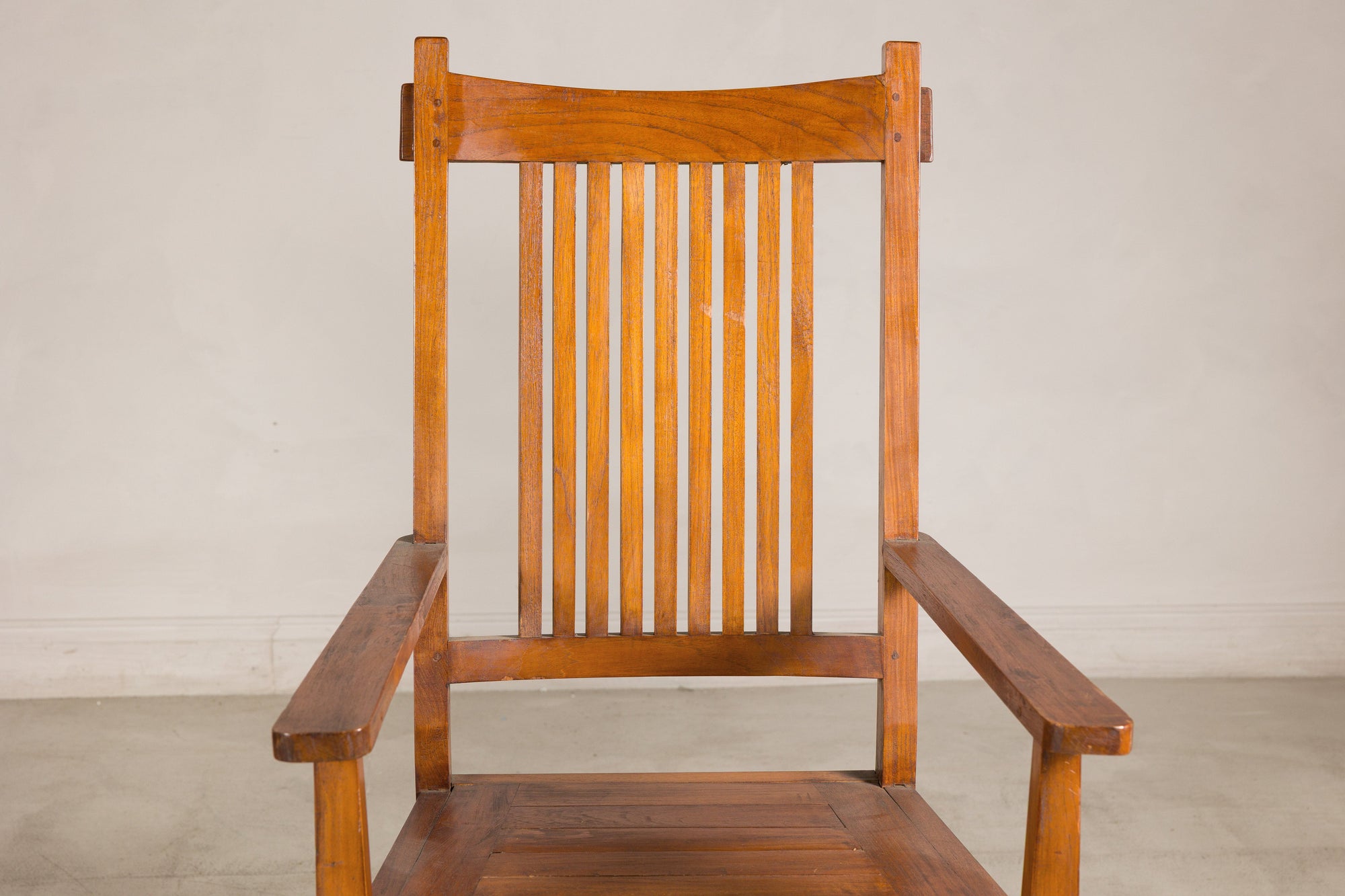 Close-up of teak armchair slatted back and curved arms