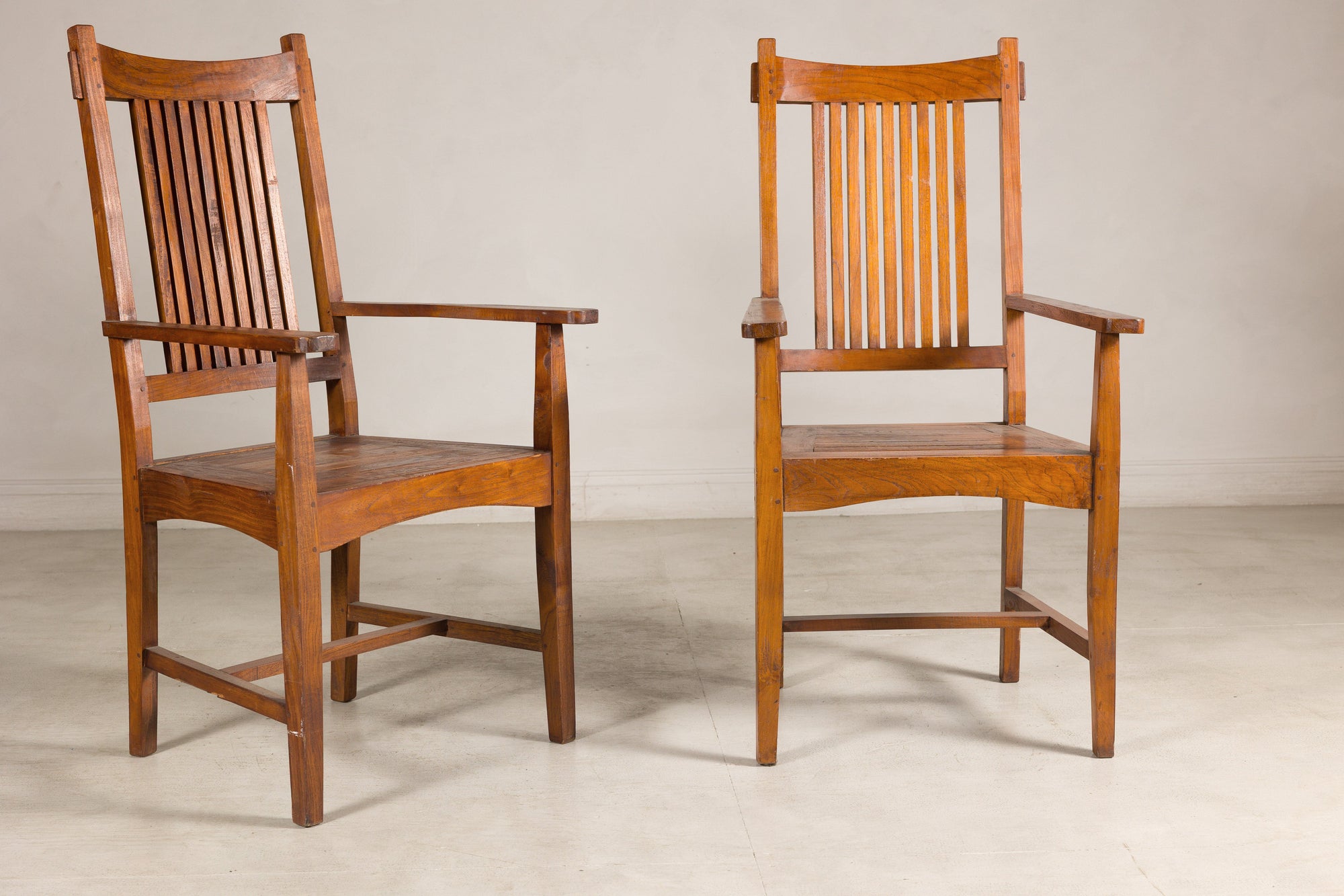 Pair of teak Dutch Colonial armchairs, angled view