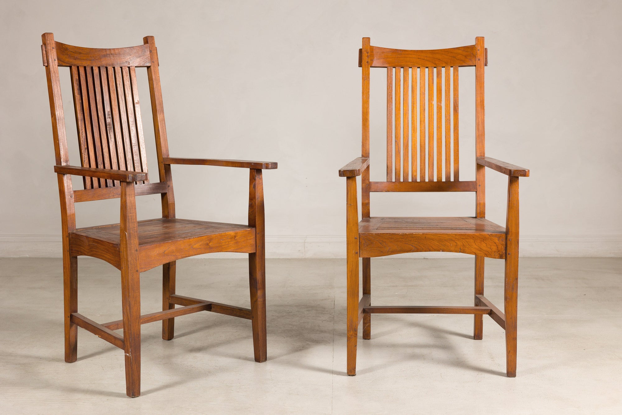 Pair of teak Dutch Colonial chairs, three-quarter views