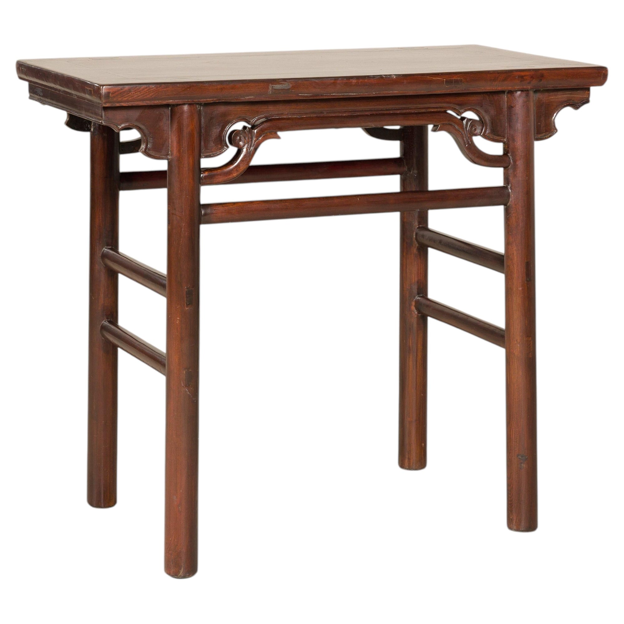 Brown Chinese elm console table, rectangular with four round legs and carved spandrels in Qing dynasty style.