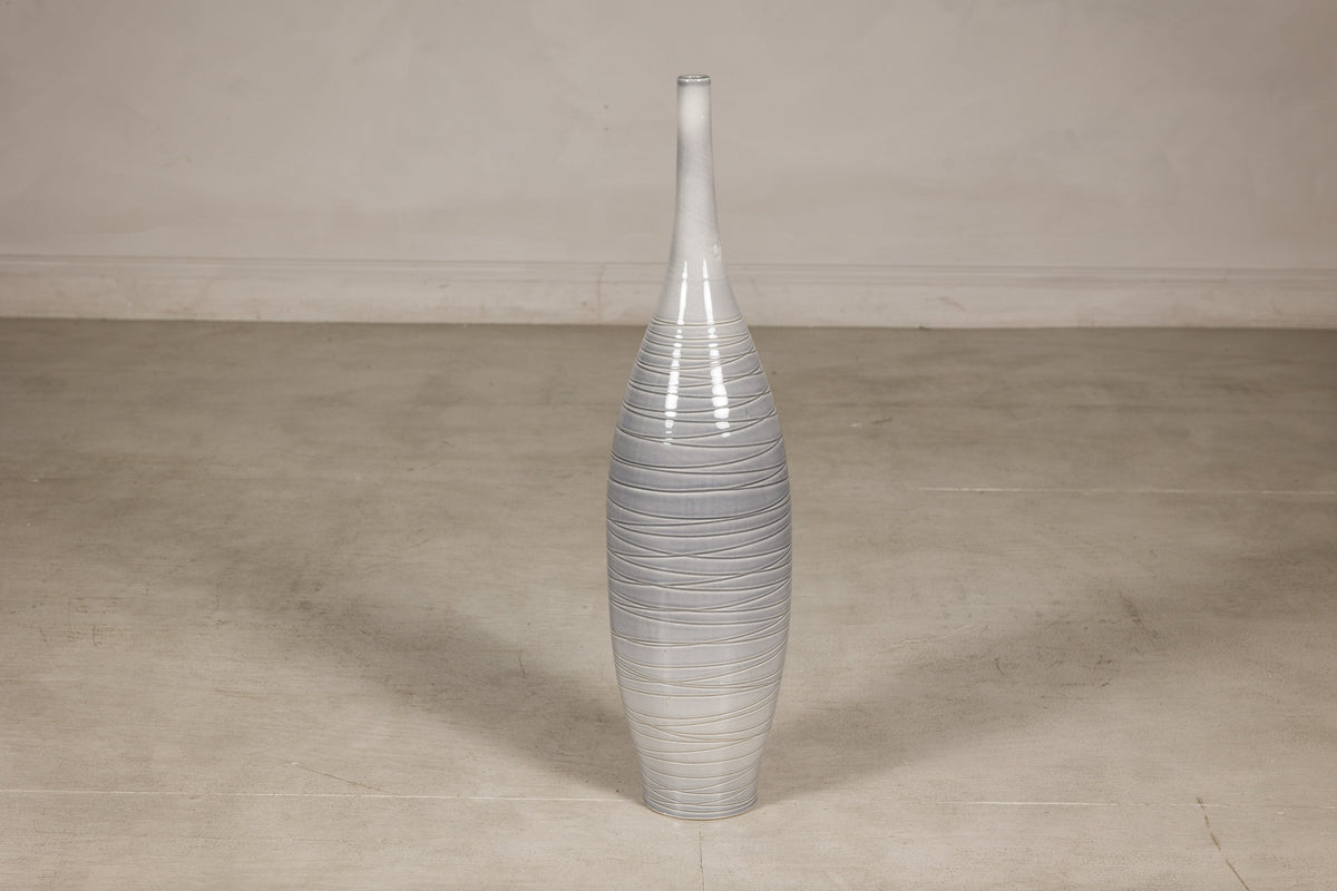 Gray-glazed ceramic bottle vase with horizontal spiral incising.