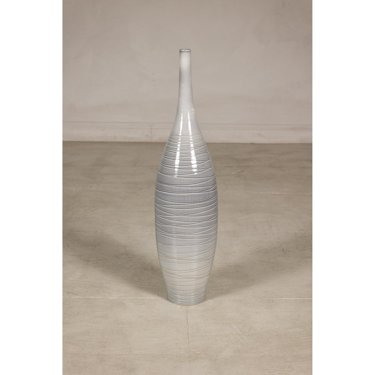 Gray ceramic bottle vase with spiral incising and glazed finish.
