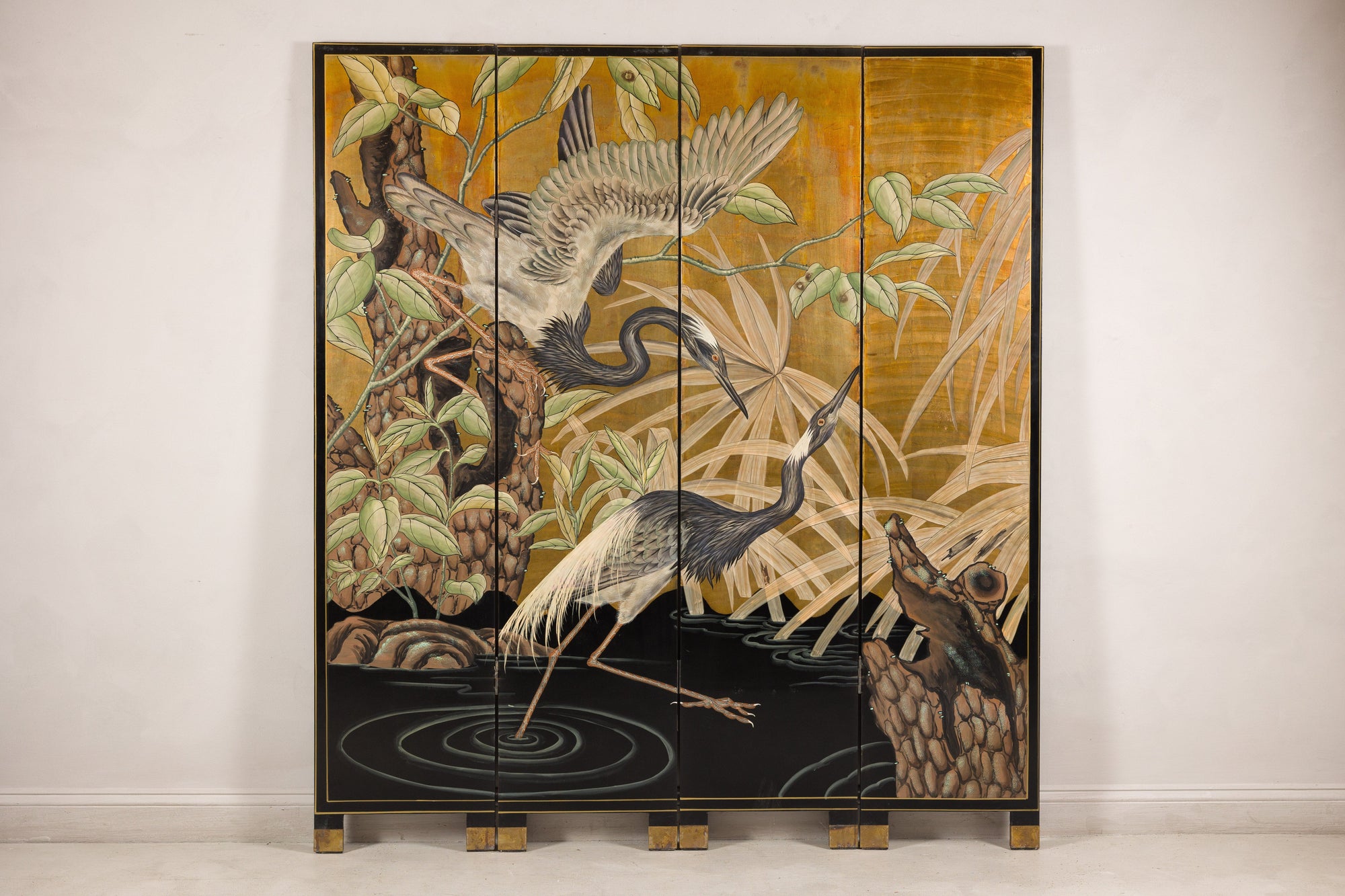 Gold-tone vintage Chinese four-panel screen with crane design on a light floor.