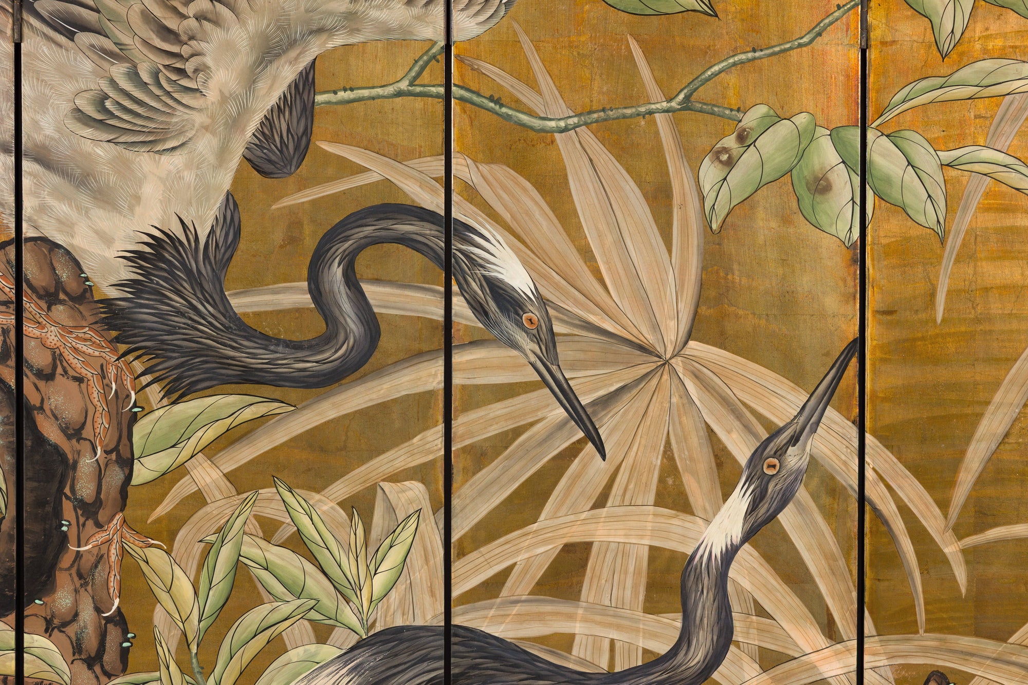 Close-up of painted cranes and foliage on gold-tone panels