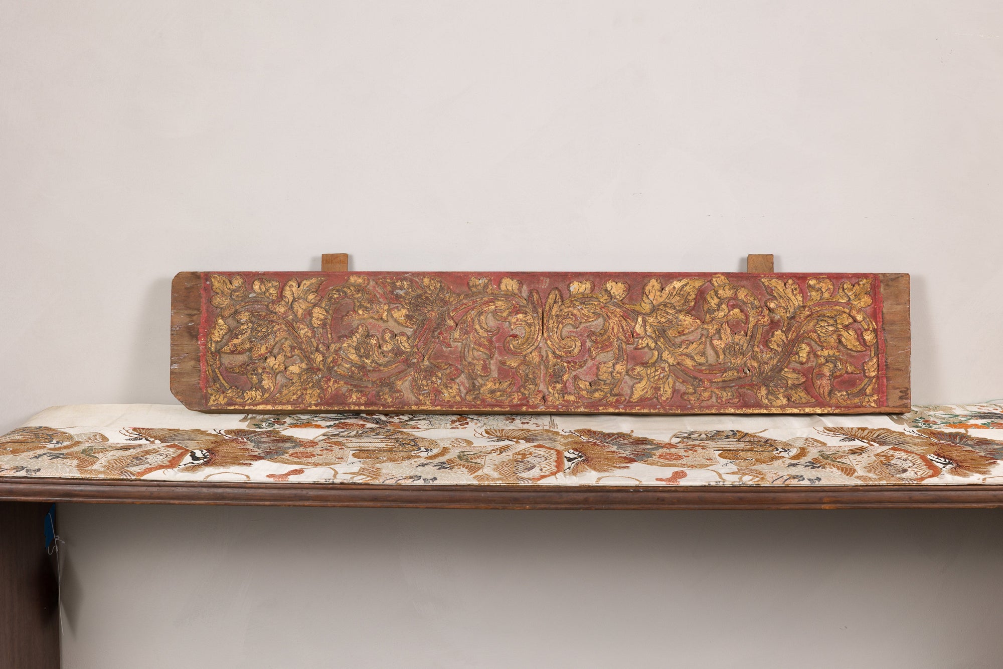 Gilt and red carved wood architectural panel angled view