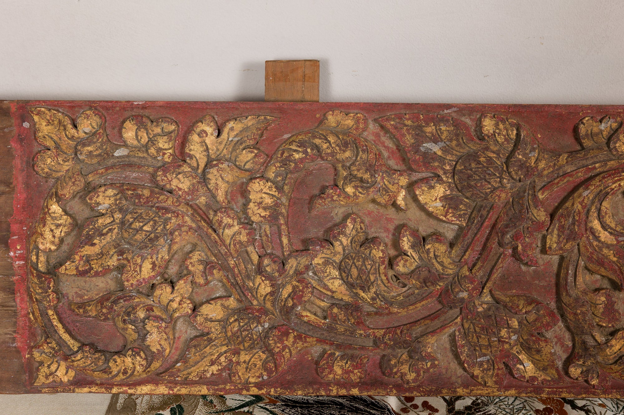 Gilt and red carved wood architectural panel close-up detail