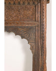 Brown hand-carved wooden Indian architectural frame with scalloped arch, displayed against a white background.