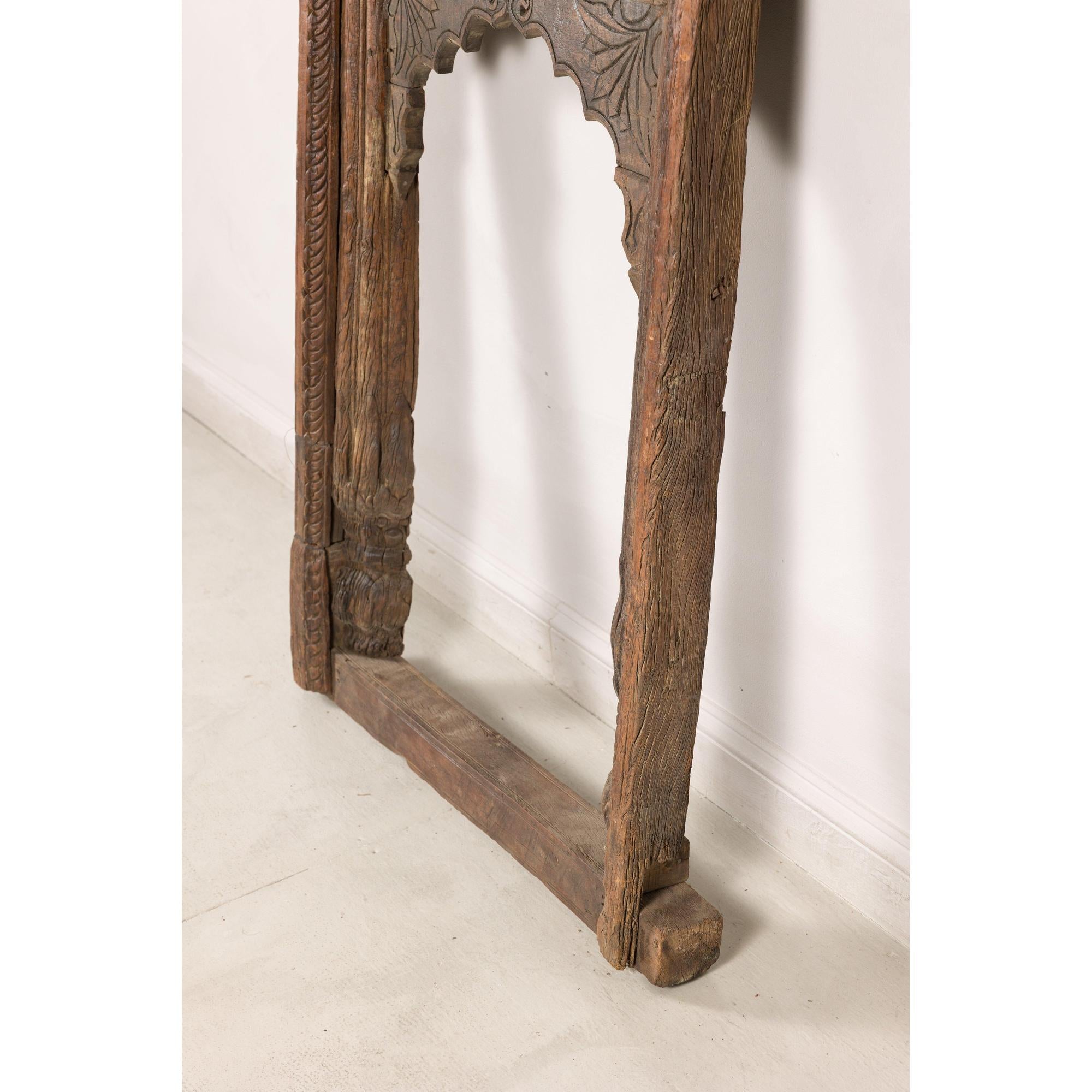 Angled view of lower side of carved architectural frame