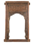 Brown wood hand-carved Indian frame with arched opening, geometric patterns, and leaf details, close-up view.