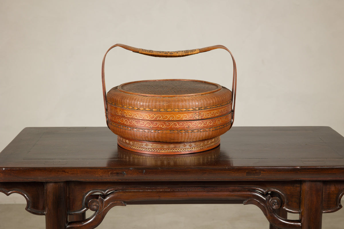 Painted vintage rattan basket on dark wood table.