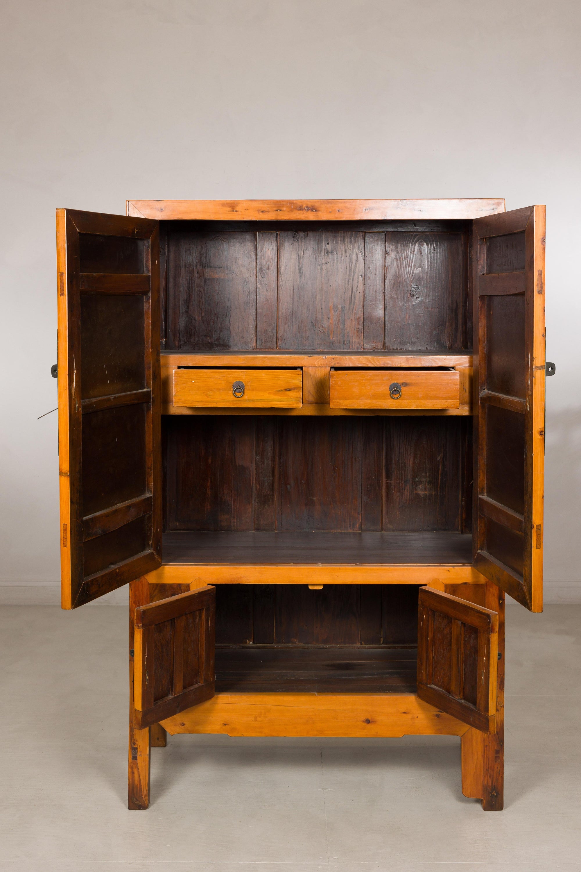Brown Chinese elm and burl wood cabinet with brass hardware, doors open to show two drawers and shelves inside.