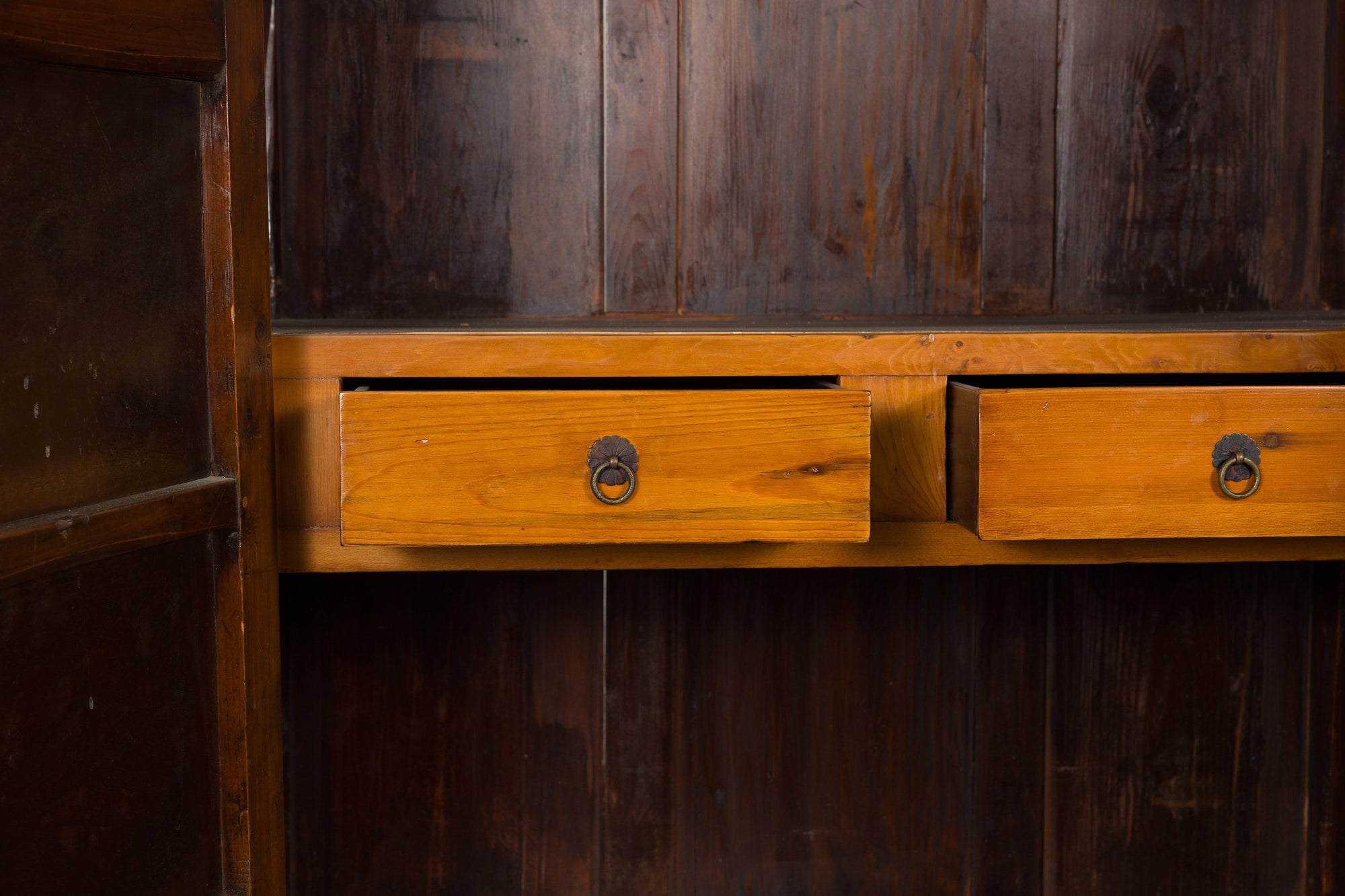 Close-up of two open drawers with brass hardware in an antique Chinese elm and burl wood cabinet.