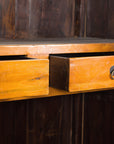 Brown Chinese elm and burl cabinet with brass hardware, two drawers partially open, against dark wood background.