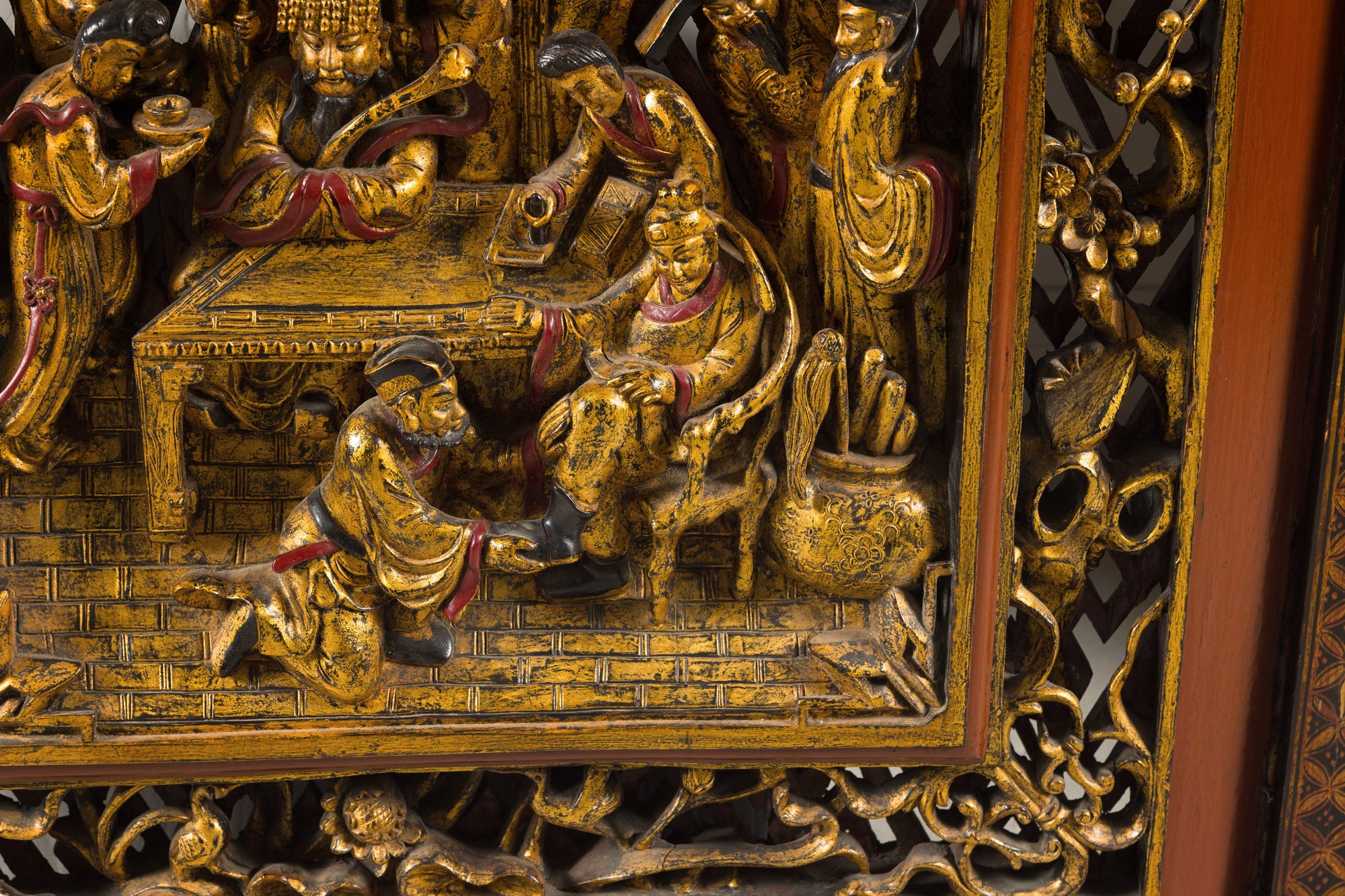Close-up of seated dignitary and attendants in carved giltwood