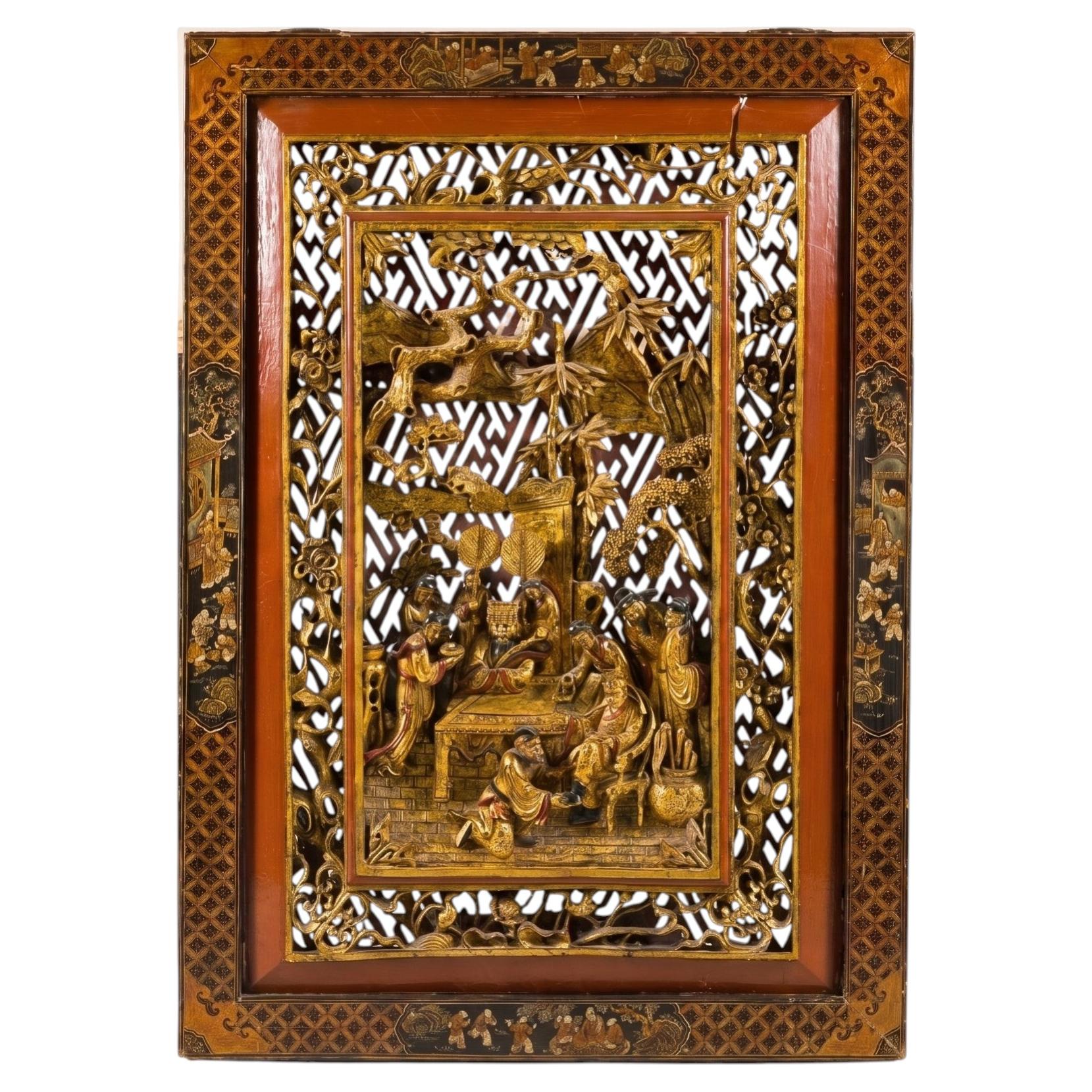 Gold giltwood Qing wall panel with carved figural court scene and ornate wooden frame, close-up view.