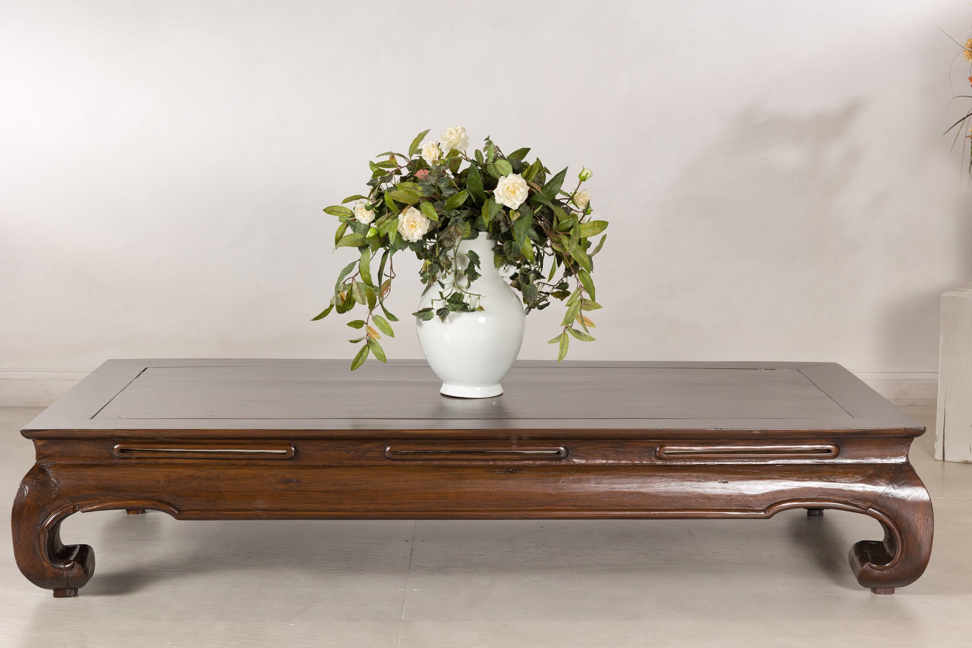 Low elm kang table styled with a white vase and flowers