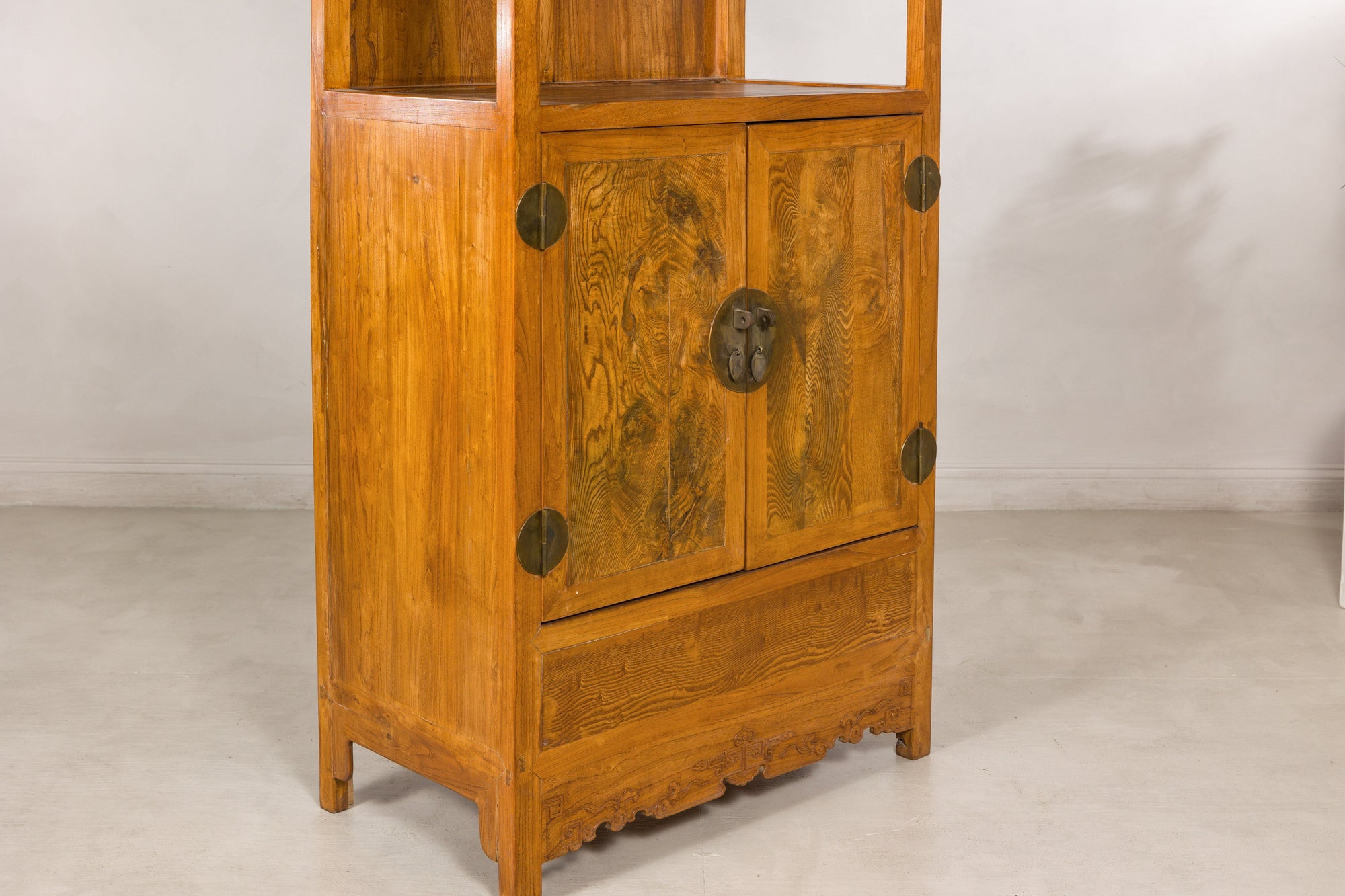 Lower left angled view of burlwood doors and carved base