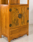 Lower left angled view of burlwood doors and carved base