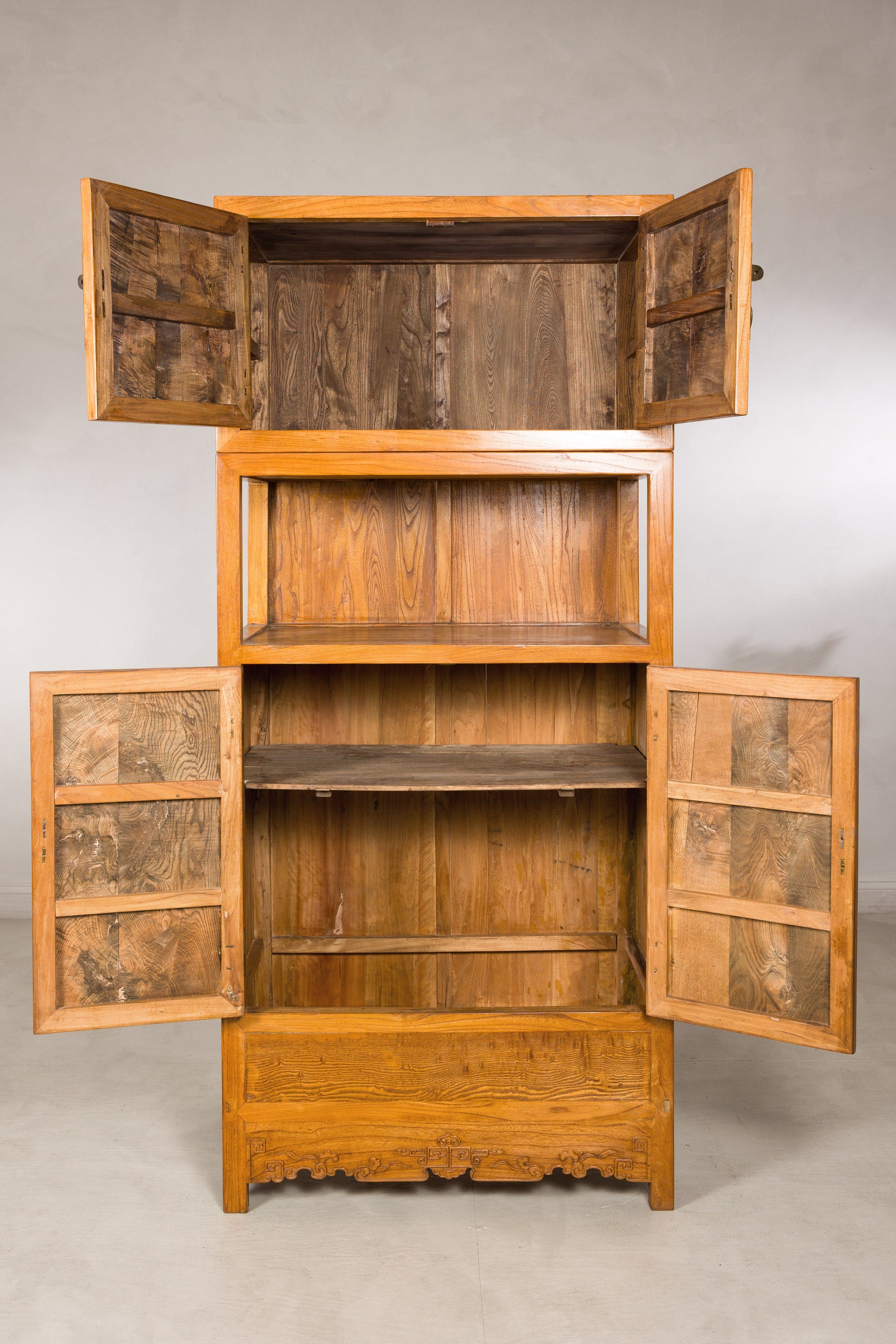 Tall Chinese cabinet with upper and lower doors open to interior shelves