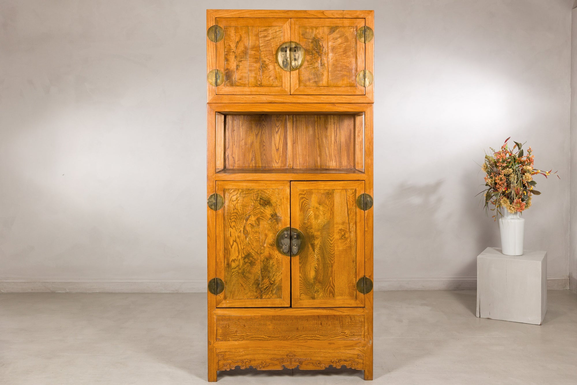 Tall Chinese elm and burlwood cabinet displayed with flowers