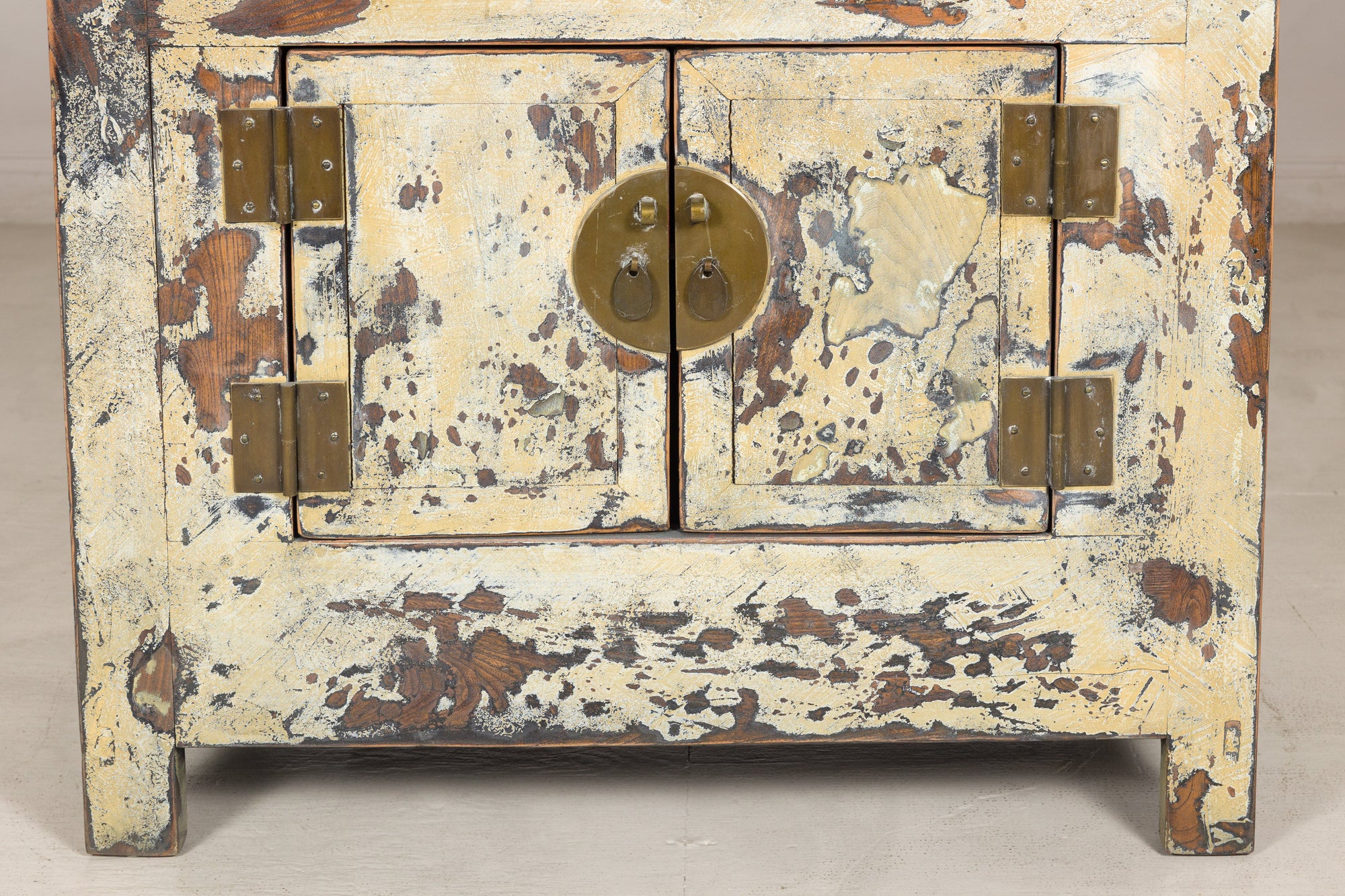 Close-up of cabinet doors, hinges and round brass lock plate