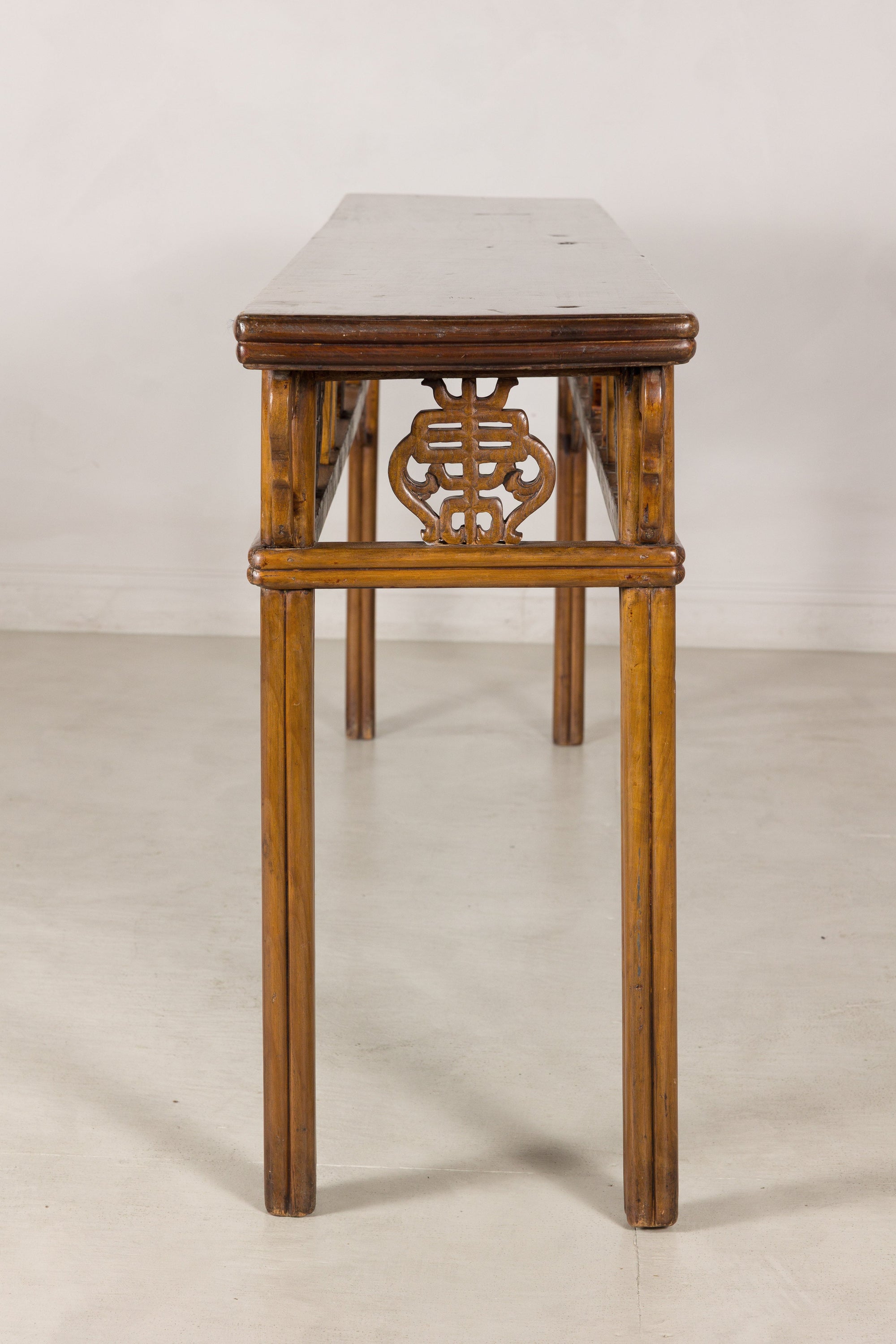 End profile showing the narrow top and carved apron motif
