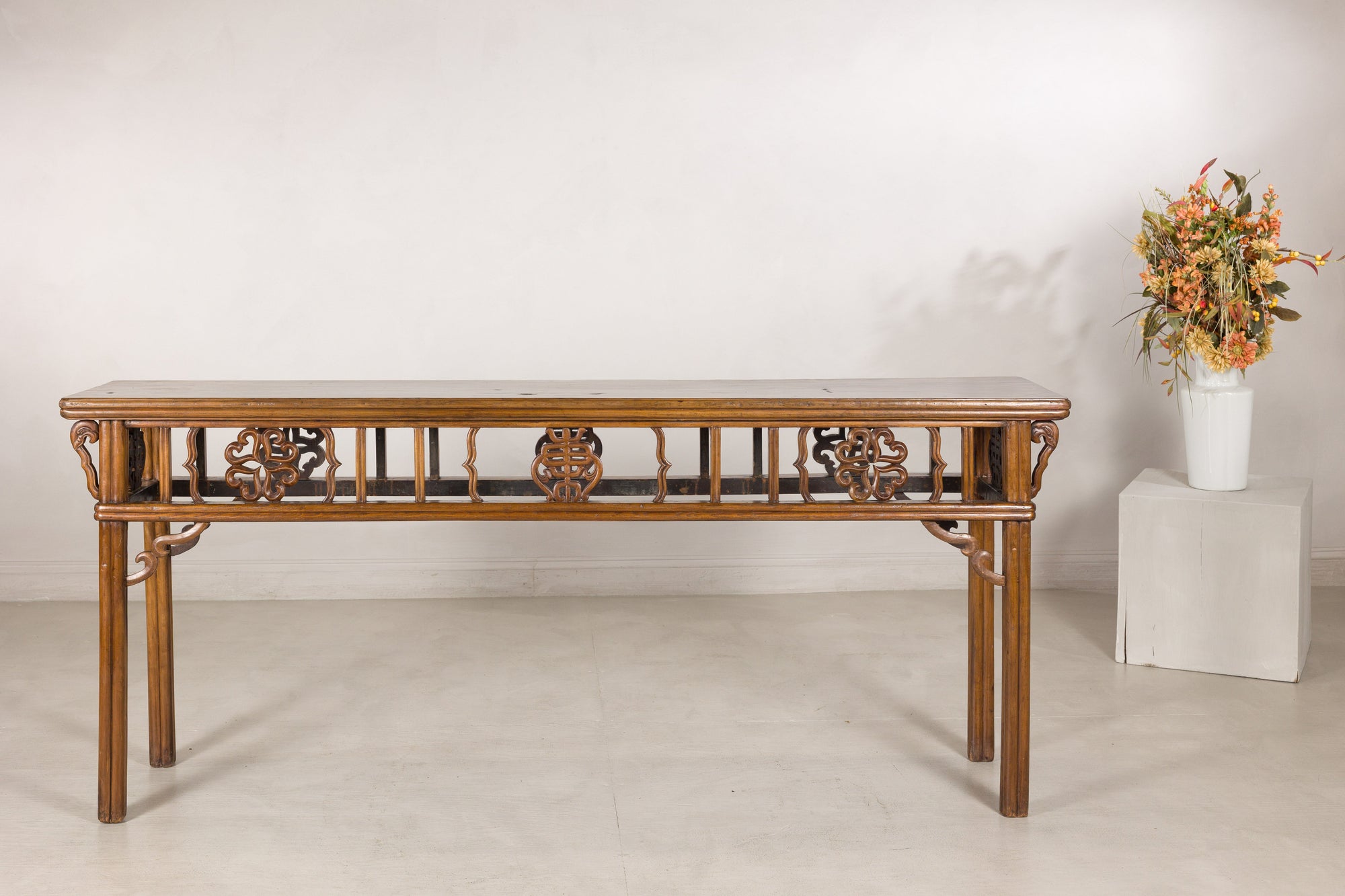 Antique Chinese console table displayed with a floral arrangement