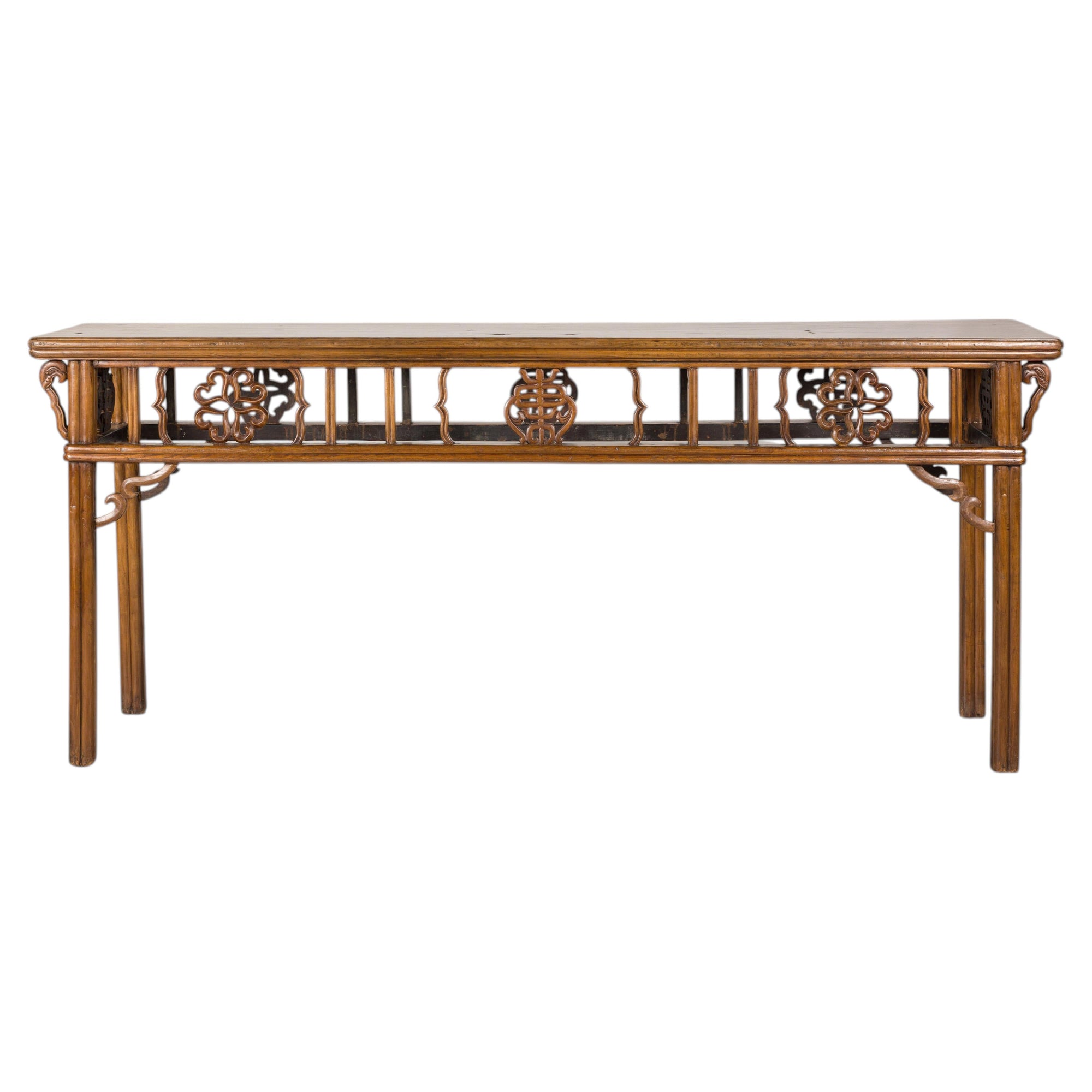 Long Chinese console table with carved openwork apron on a white background