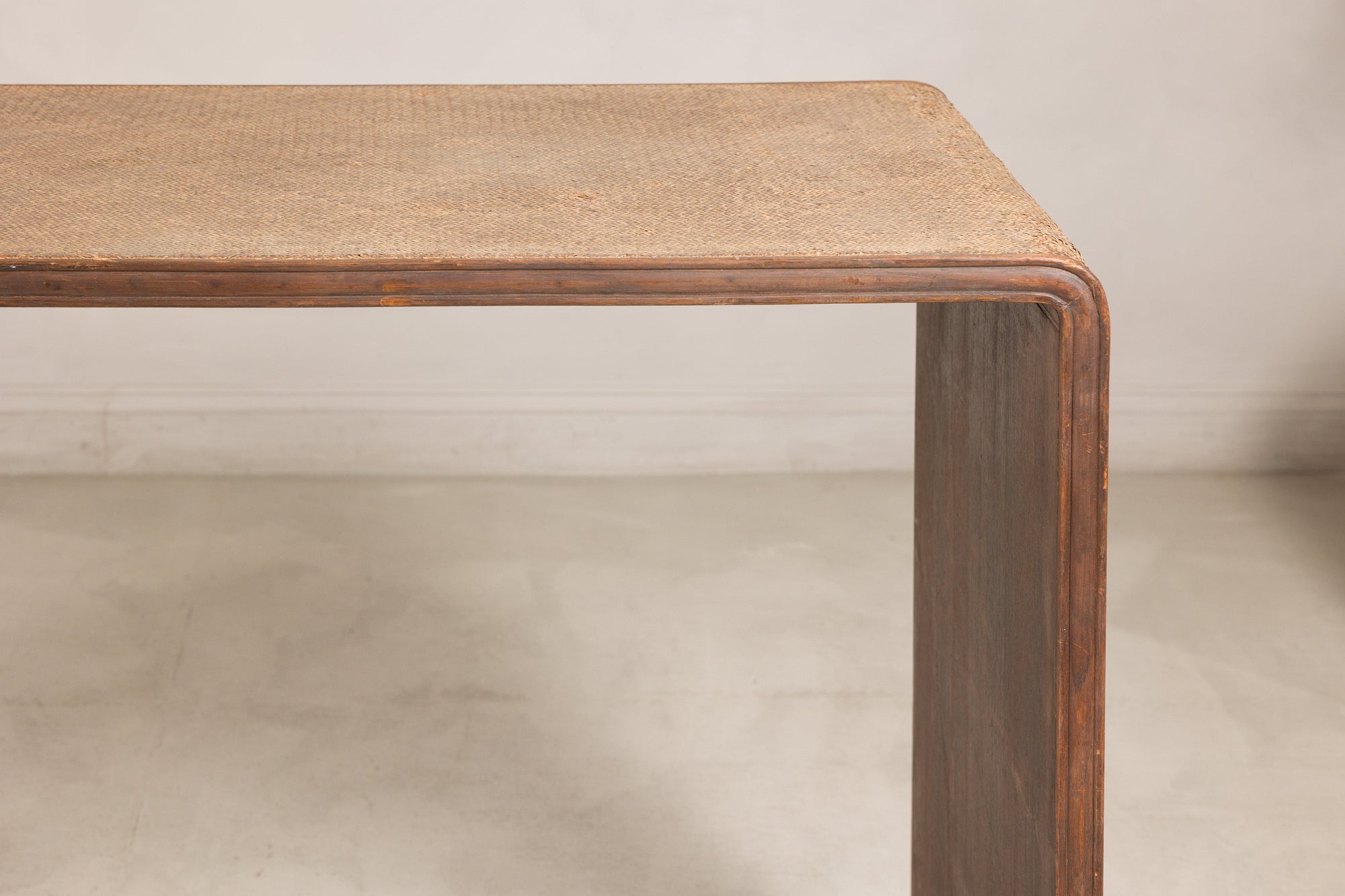 Close-up of the rounded wood corner and woven rattan top