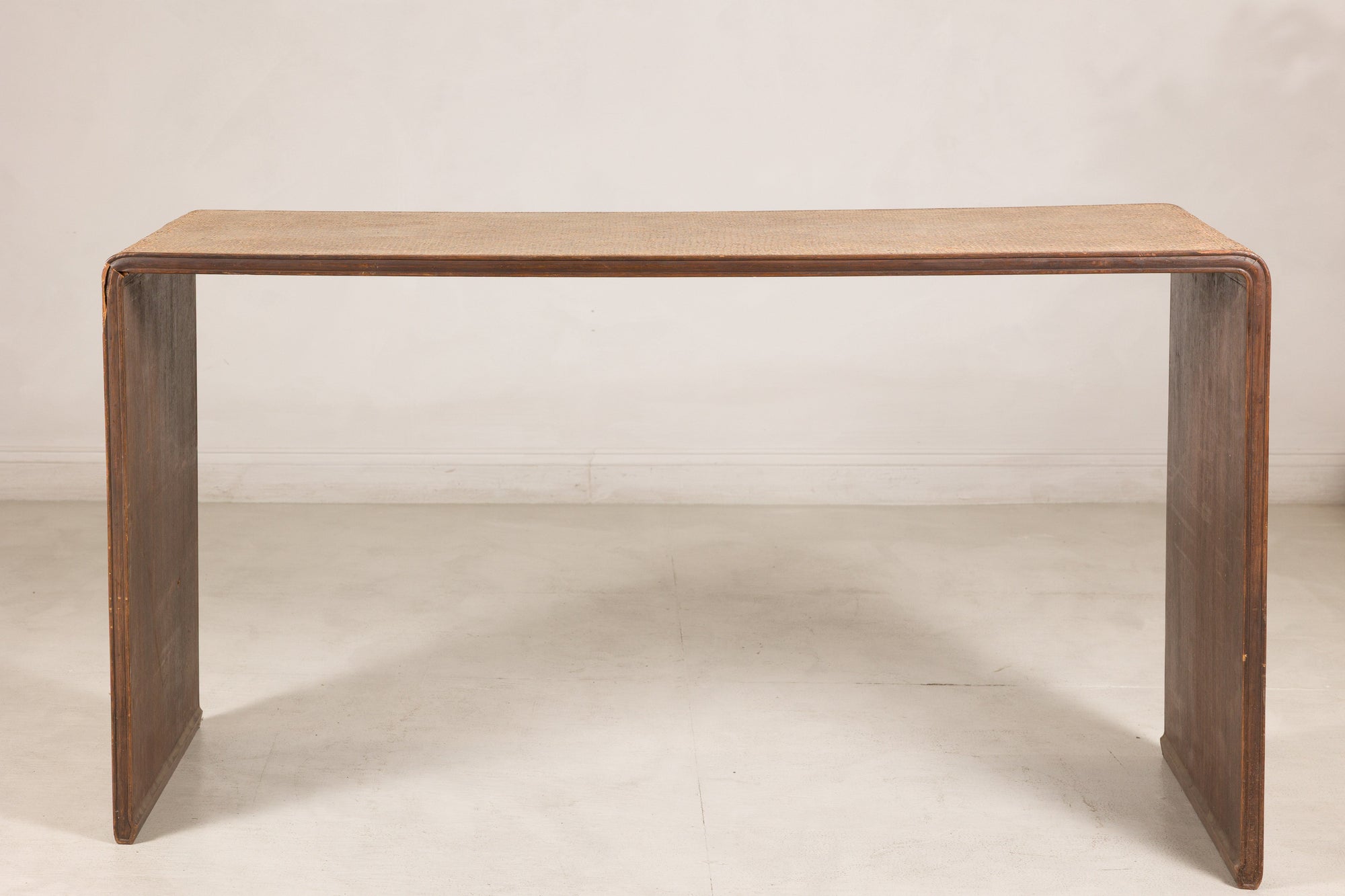 Front view of the rattan and wood waterfall console table