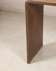 Close-up of a dark wood side panel and rounded top corner