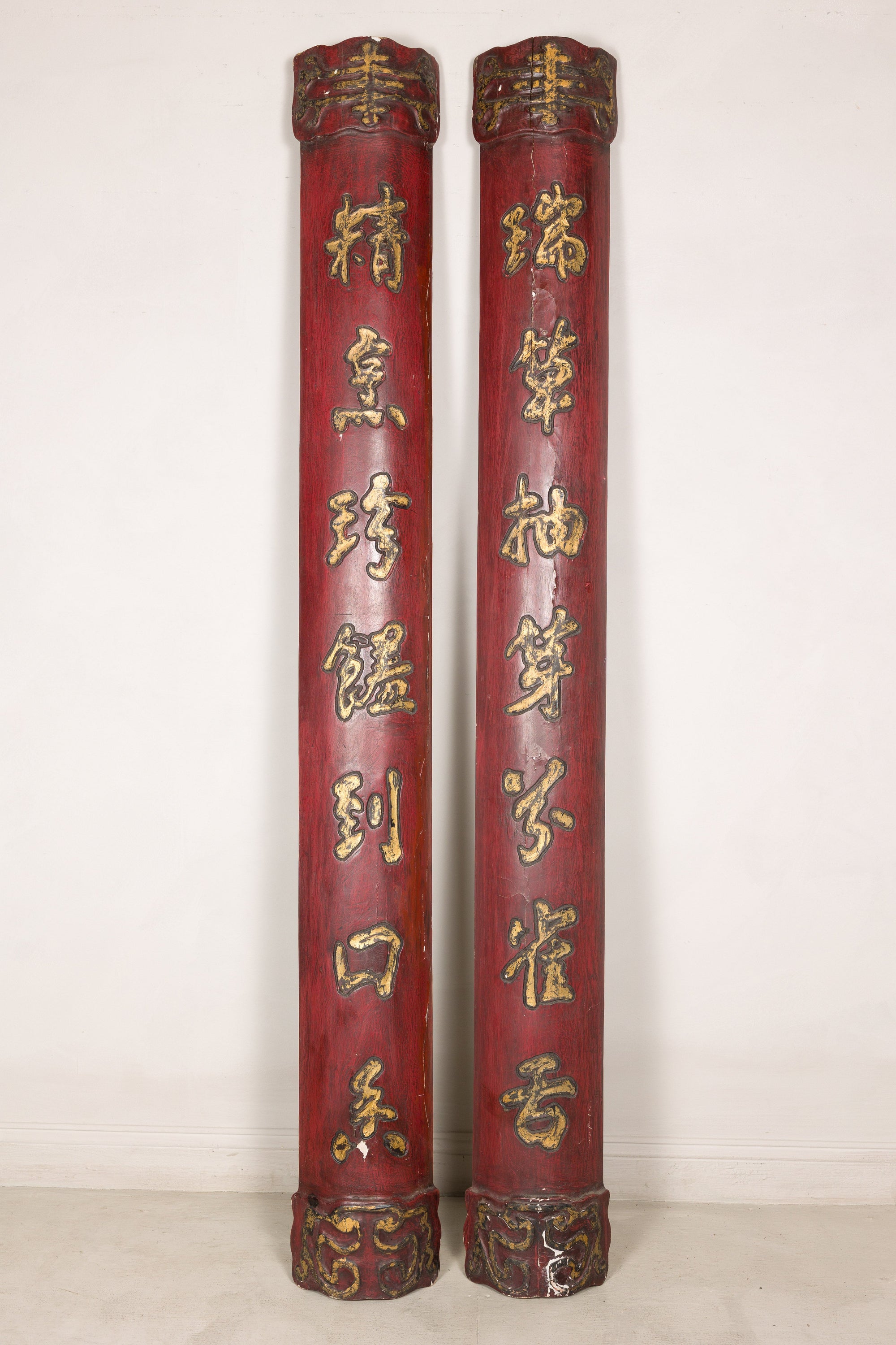 Alternate front view of red and gilt calligraphy panels against a pale wall