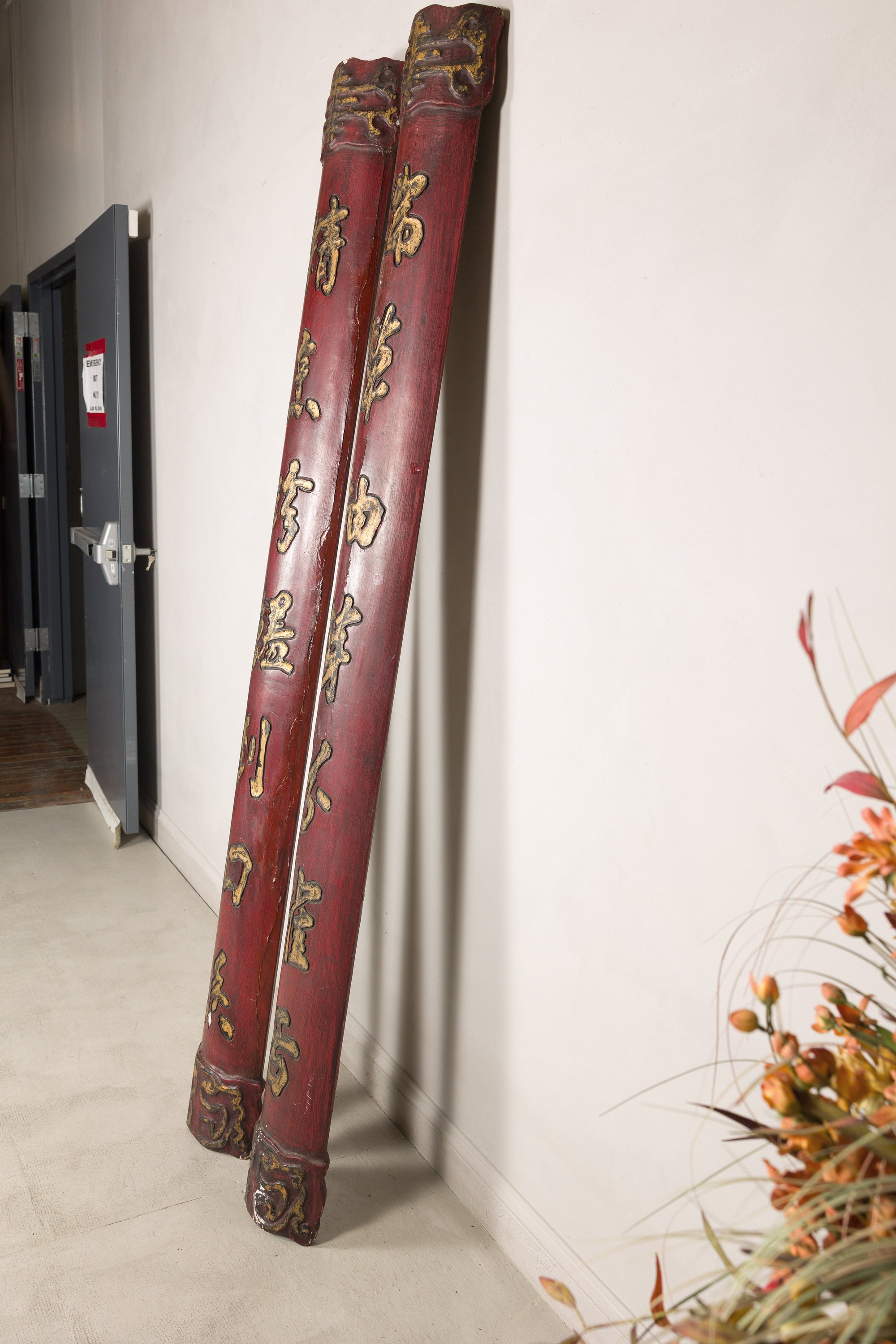 Angled view of paired red wood calligraphy panels showing their rounded profiles