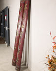 Angled view of paired red wood calligraphy panels showing their rounded profiles